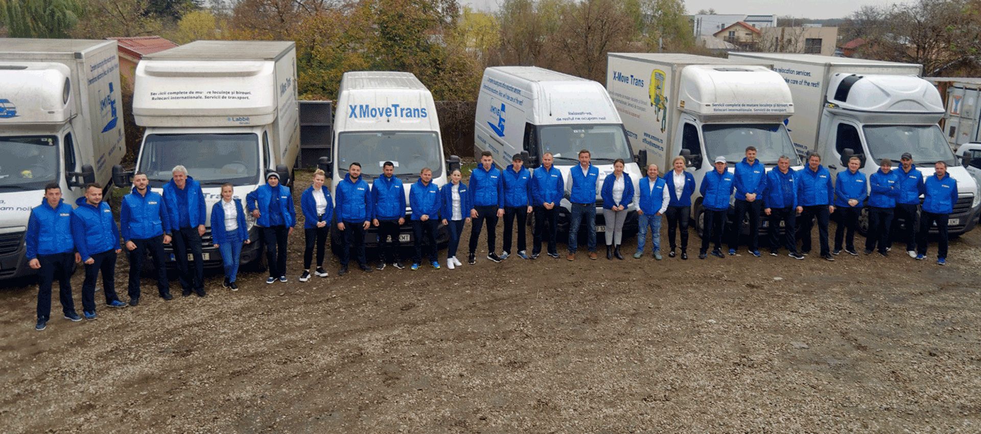 Echipa XMoveTrans în fața flotei de camioane